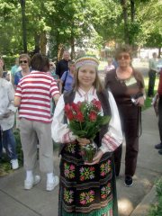 Dressed in traditional Lithuanian costume, Kourtney Baker holds roses that she will give to participants to commemorate loved ones at the dedication ceremony.